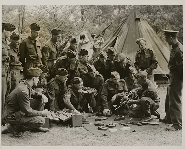 Members of the H.G. at a camp learn how a Tommy gun is constructed.