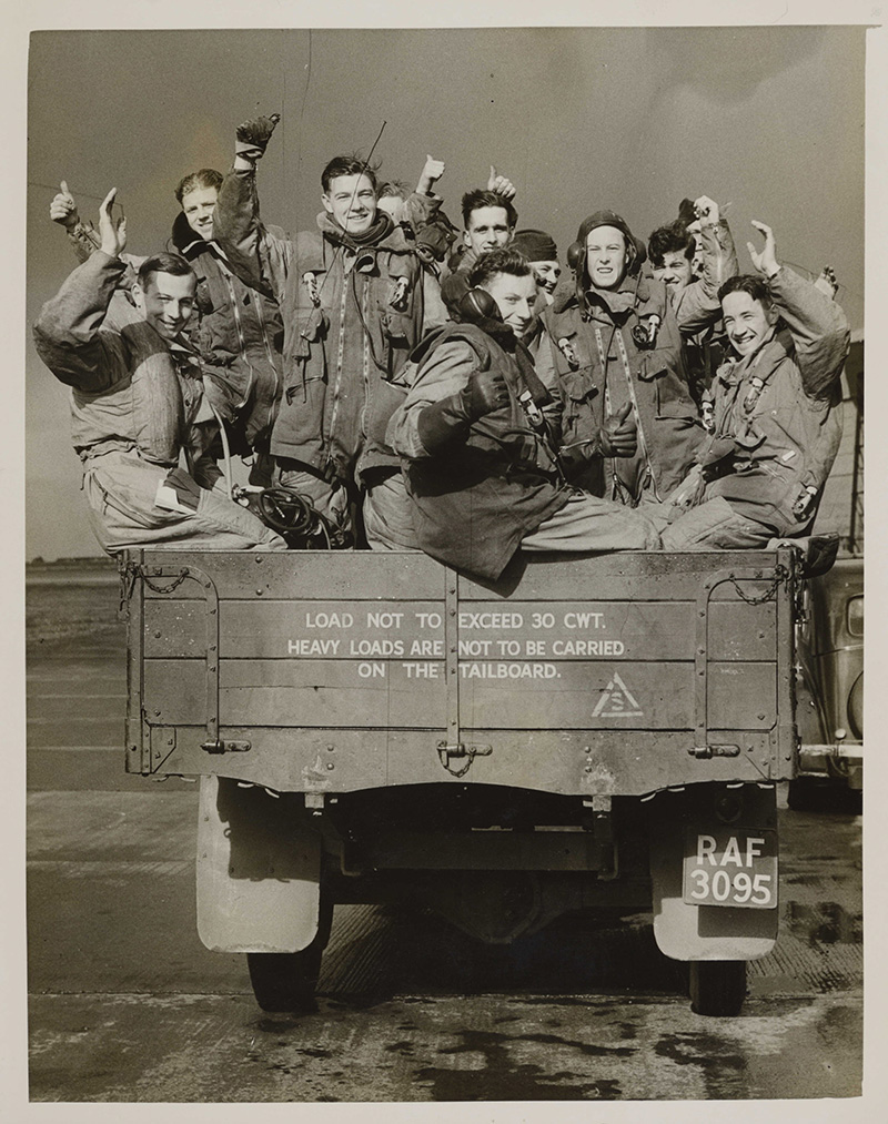 A bomber crew loaded on the lorry which gives them a lift to their plane.