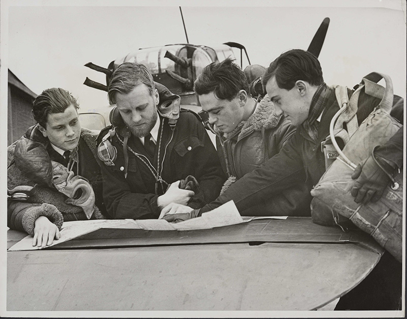 Pilots discuss routes on a map prior to a training flight.