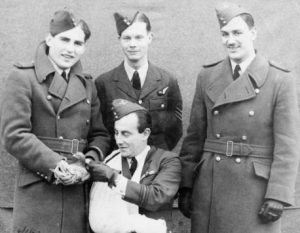 The four members of the Bristol Beaufort bomber, Number 42 Squadron RAF, which crashed into the sea in February 1942, with Winkie the pigeon. The four men are in RAF uniforms, with one man seated, his arm in a sling. One of the men is holding the pigeon. Winkie was later awarded the Dickin Medal for her bravery. © IWM (HU 45623). 
