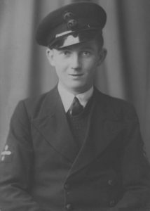 William Denning in naval uniform during WWII. William's cap is worn at a slight angle. He is wearing a shirt and tie and a sweater under his naval jacket. The patch on William's right arm, depicting a two-bladed propeller with a star above and beneath it, indicates he was a Motor Mechanic. Image provided by Anthony Denning. 
