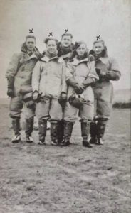 James Tough Gibson and his RAF crewmates during WWII. They are all wearing coveralls over their uniforms. James is in the front row, holding a helmet. The other men in the photo, with crosses above their heads, did not survive the war. Image provided by Joann Arthur. 